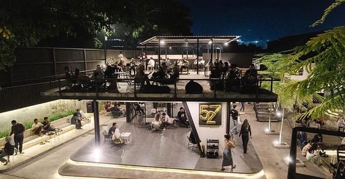 Suasana malam di 527 Café Serang dengan konsep dua lantai outdoor yang ramai pengunjung, menjadi tempat nongkrong favorit yang direkomendasikan Dream Home Specialist The Hana Park.